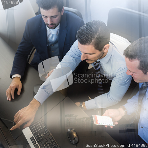 Image of Business team analyzing data on computer.