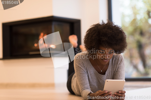 Image of black women used tablet computer on the floor