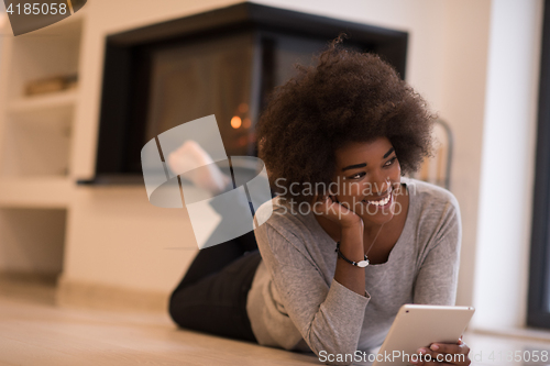 Image of black women used tablet computer on the floor