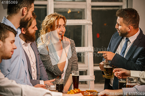 Image of Group of friends enjoying evening drinks with beer