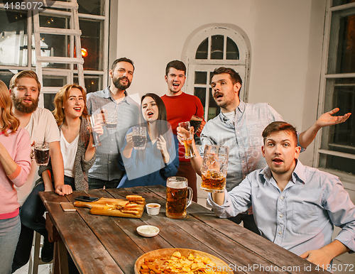 Image of Group of friends enjoying evening drinks with beer