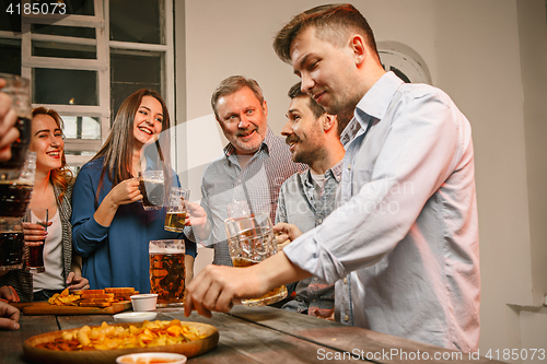 Image of Group of friends enjoying evening drinks with beer