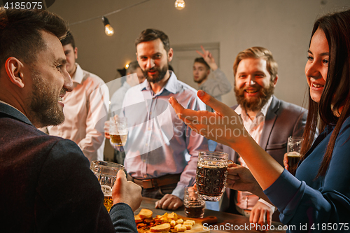 Image of Group of friends enjoying evening drinks with beer