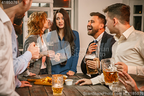 Image of Group of friends enjoying evening drinks with beer