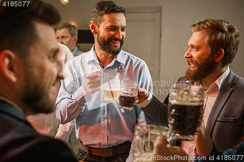 Image of Group of friends enjoying evening drinks with beer