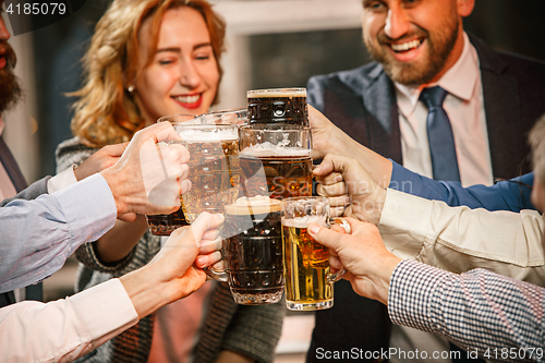 Image of Group of friends enjoying evening drinks with beer