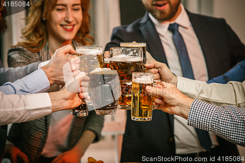 Image of Group of friends enjoying evening drinks with beer