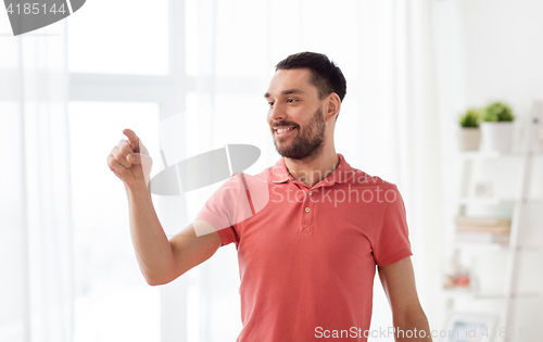 Image of happy man touching something imaginary at home