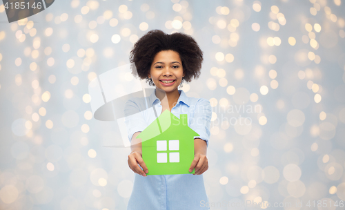 Image of happy african american woman with green house icon