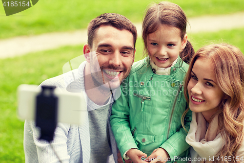 Image of happy family taking selfie by smartphone outdoors