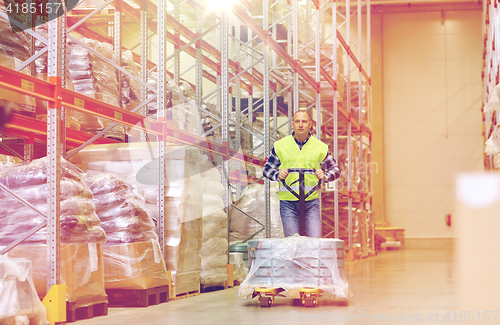 Image of man carrying loader with goods at warehouse