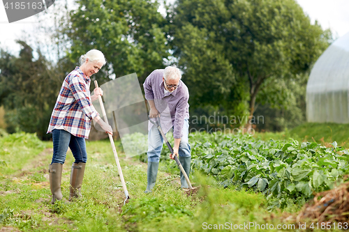 Image of senior couple with shovels at garden or farm