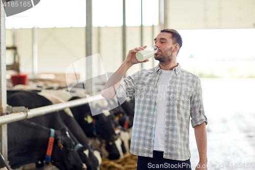 Image of man or farmer drinking cows milk on dairy farm