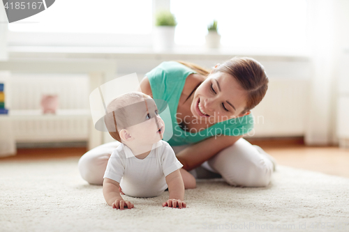 Image of happy mother playing with baby at home