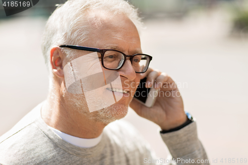 Image of happy senior man calling on smartphone in city