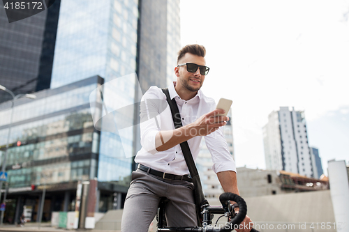 Image of man with bicycle and smartphone on city street