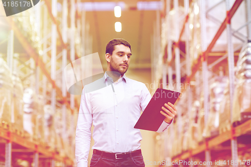 Image of businessman with clipboard at warehouse