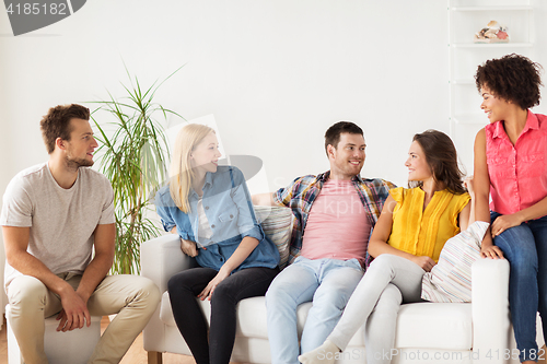 Image of group of happy friends talking at home