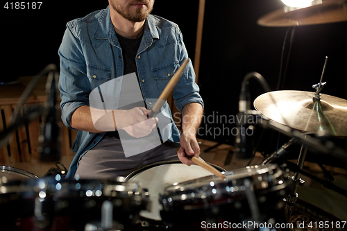 Image of male musician playing drums and cymbals at concert