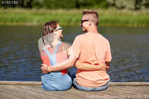 Image of happy teenage couple hugging on river summer berth