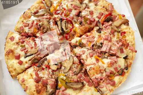 Image of close up of pizza in paper box on table