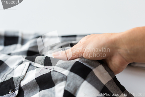 Image of close up of hand with checkered clothing item