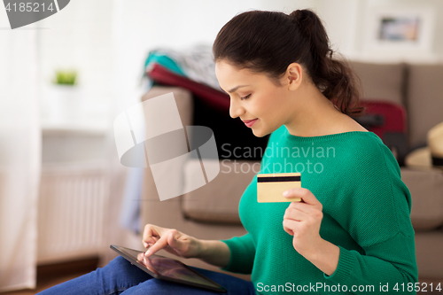 Image of woman with tablet pc and credit card at home