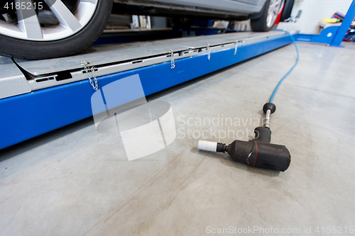 Image of screwdriver and car at tire shop