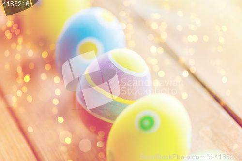 Image of close up of colored easter eggs on wooden surface