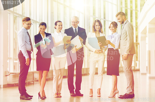 Image of business team with tablet pc and folders at office