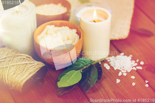 Image of close up of natural body scrub and candles on wood