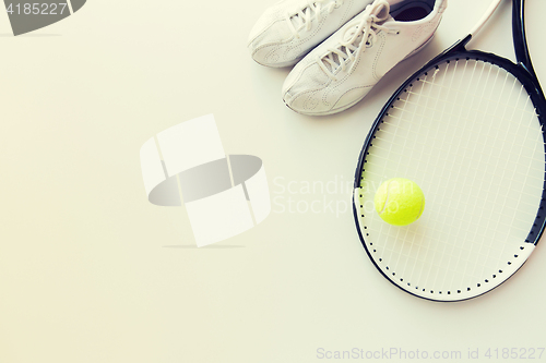 Image of close up of tennis racket with ball and sneakers