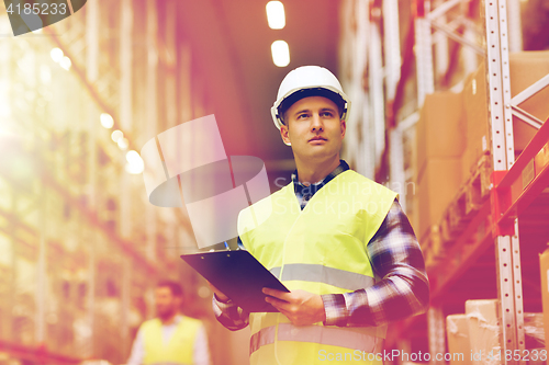 Image of man with clipboard in safety vest at warehouse