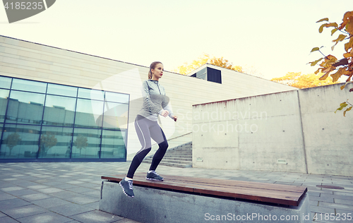 Image of woman exercising on bench outdoors
