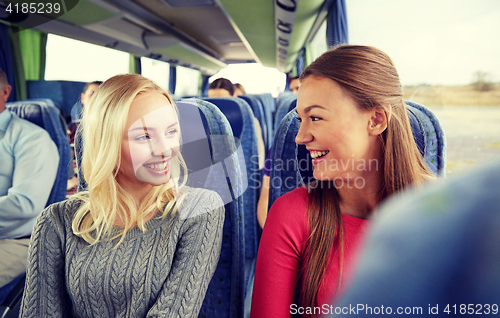 Image of happy young women talking in travel bus