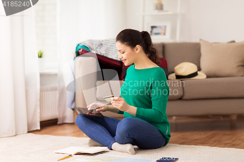 Image of woman with tablet pc and credit card at home