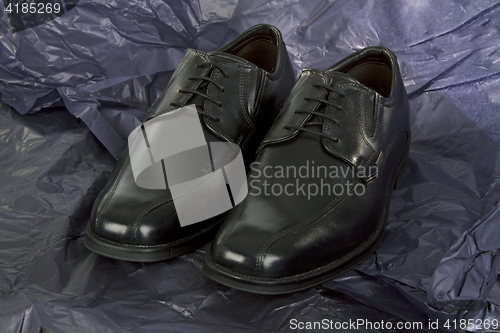 Image of Black Mens shoes on black Paper