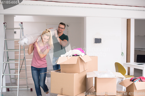 Image of couple carrying a carpet moving in to new home