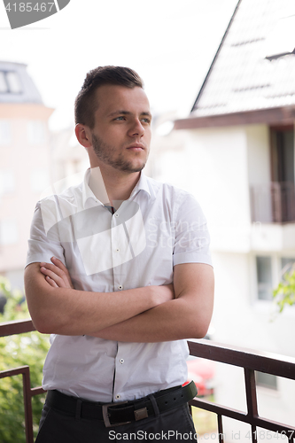 Image of man standing at balcony