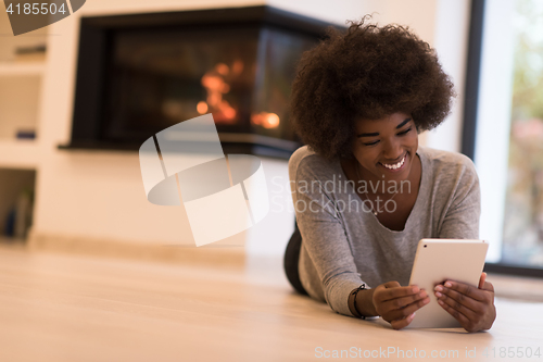 Image of black women used tablet computer on the floor