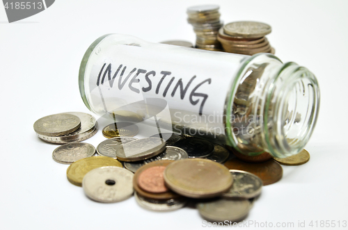 Image of Investment lable in a glass jar with coins spilling out