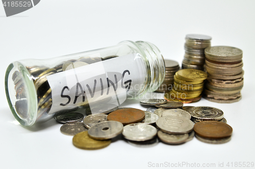 Image of Saving lable in a glass jar with coins spilling out