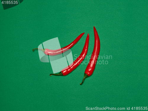 Image of bitter chili pepper and paprika on a green background