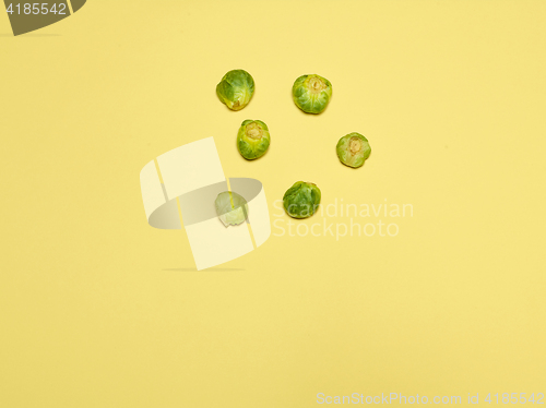 Image of The piles of Brussels sprouts on a yellow background