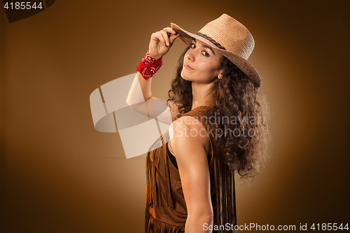 Image of The cowgirl fashion woman over a brown background