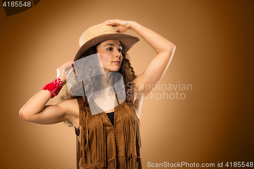 Image of The cowgirl fashion woman over a brown background