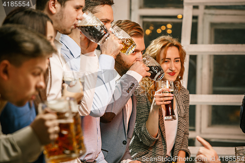 Image of Group of friends enjoying evening drinks with beer