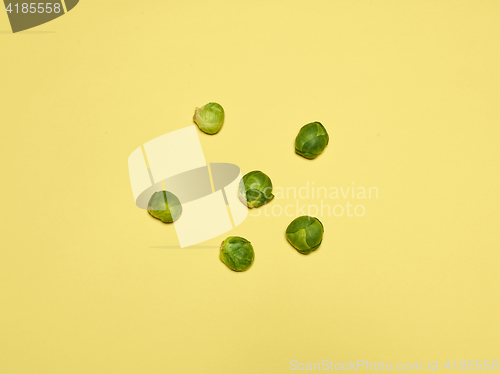 Image of The piles of Brussels sprouts on a yellow background