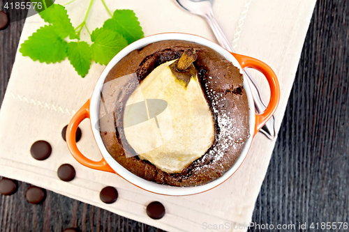 Image of Cake chocolate with pear in red bowl on napkin top