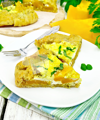 Image of Pie of pumpkin and basil in plate on towel